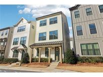 Charming three-story townhome featuring a welcoming front porch and modern architectural details at 2435 Folly Se Ln, Atlanta, GA 30339