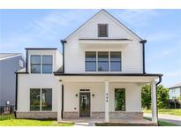 Charming two-story home with a white exterior, covered porch, and manicured lawn at 648 Liella Se Park, Atlanta, GA 30312