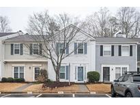 Exterior view of townhomes featuring vinyl siding, traditional windows, and well-kept front lawns at 3994 Wolcott Cir, Atlanta, GA 30340