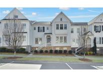 Charming townhouse featuring white siding, stone accents, and a welcoming front porch at 313 Booth St, Woodstock, GA 30188