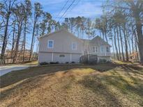 Charming two-story home with gray siding, a bay window and mature trees at 2473 Chauncey Sw Ln, Marietta, GA 30064