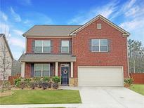 Charming brick two-story home with a well-manicured lawn and attached two-car garage at 3062 Hawthorn Farm Blvd, Loganville, GA 30052