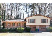 Charming two-story home with a brick and siding exterior, attached garage, and inviting front porch at 3969 Briaridge Cir, Atlanta, GA 30340