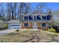 Charming two-story brick home featuring a well-maintained lawn and attached two-car garage at 423 James Sw St, Lilburn, GA 30047