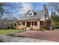 Charming brick home featuring a welcoming front porch, red door, and beautiful brick driveway at 914 Adair Ne Ave, Atlanta, GA 30306