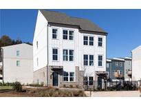 Modern three-story townhome featuring bright white siding and brick accents beneath a contemporary roofline at 341 Skylar Se Way, Atlanta, GA 30315