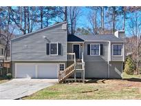 Charming home featuring a two-car garage, traditional siding, and a welcoming front entrance at 6010 Woodland Nw Dr, Kennesaw, GA 30152