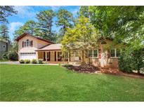 Charming two-story home with a well-manicured lawn and mature trees at 2542 Maclaren Cir, Dunwoody, GA 30360
