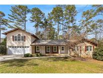 Charming home with a well-manicured front lawn and a welcoming covered porch perfect for relaxing at 2542 Maclaren Cir, Dunwoody, GA 30360