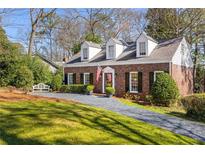Charming brick home with black shutters, dormer windows, and a well-manicured front yard at 6785 Wright Ne Rd, Atlanta, GA 30328