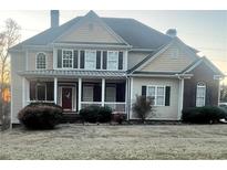 Charming home with inviting front porch, well-maintained landscaping, and a classic design with a red door at 2532 Greenes Ln, Powder Springs, GA 30127
