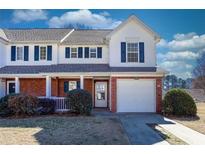 Charming two-story townhome with brick accents, blue shutters and a well-manicured front lawn at 269 Cottonwood Creek Cir, Canton, GA 30114