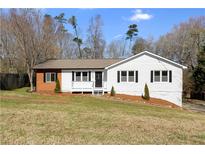 Charming single-story home with white siding, black shutters, and a well-manicured front lawn at 215 Sabrina Ct, Woodstock, GA 30188