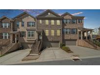 Beautiful brick townhomes with attached garages and inviting stairways lead to the front entrances at 2478 Georgetown Ave, Atlanta, GA 30345