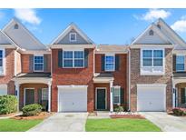 Charming brick townhome featuring an attached garage, green grass, and dark shutters for an elegant curb appeal at 2409 Heritage Park Nw Cir # 14, Kennesaw, GA 30144