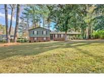 Charming two-story brick home with a well-maintained front lawn and mature trees at 7546 Palmetto Way, Riverdale, GA 30274