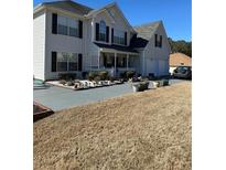 Charming two-story home featuring a welcoming front porch, well-maintained landscaping, and a two-car garage at 709 Mohansic Ave, Loganville, GA 30052