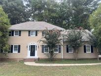 Traditional two-story home boasts black shutters, mature trees, and a classic front door at 1261 William Robert Sw Dr, Marietta, GA 30008
