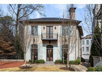 Elegant stone home featuring a charming balcony and manicured front lawn at 229 Dovecrest Nw Dr, Atlanta, GA 30305