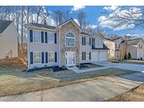 Charming two-story home featuring stone accents, black shutters, and a well-manicured lawn at 5043 Laythan Jace Ct, Snellville, GA 30039
