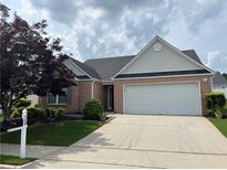 Charming brick home featuring a two-car garage and a well-maintained front yard at 710 Village Ln, Loganville, GA 30052