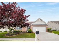 Charming one-story brick home with a well-manicured lawn, mature tree, and attached two-car garage at 710 Village Ln, Loganville, GA 30052