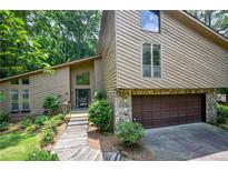 Charming home with a striking exterior, a stone-accented garage and a landscaped pathway at 2235 Six Branches Dr, Roswell, GA 30076