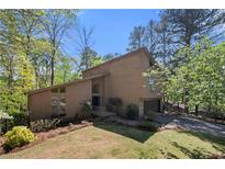 Stunning two-story home with a beautiful lawn and mature landscaping in a wooded setting at 2235 Six Branches Dr, Roswell, GA 30076