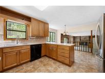 Bright eat-in kitchen featuring tile flooring, wood cabinets and stainless steel refrigerator at 2235 Six Branches Dr, Roswell, GA 30076