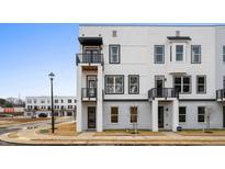 Modern townhome with white siding, black accents, and private balconies on a sunny day at 1084 Brookglynn Trce, Decatur, GA 30032