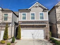 Two-story townhome featuring a brick facade and attached two-car garage at 3615 Faulkner St, Cumming, GA 30041