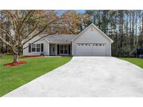 Charming single-story home with light gray siding, black shutters, well-manicured lawn and long driveway at 637 Delay Way, Stockbridge, GA 30281