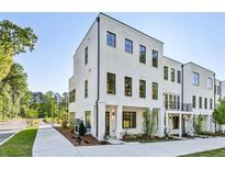 Modern, three-story white brick townhome featuring black-framed windows and manicured landscaping at 2150-5 Tidwell Ln # 5, Atlanta, GA 30318