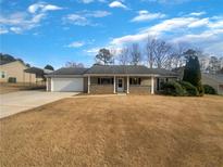 Charming single-story home featuring a classic facade, attached garage, and well-maintained landscaping at 610 Seaboard Dr, Stockbridge, GA 30281