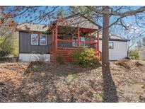 Charming home featuring a covered porch with red accents and a well-maintained yard surrounded by mature trees at 1180 Fleming St, Atlanta, GA 30080