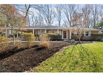 Charming brick ranch home featuring a covered parking area, lush landscaping, and mature trees at 1335 Chaucer Ne Ln, Brookhaven, GA 30319