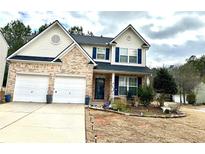Charming two-story home featuring a brick facade, two-car garage, and manicured front yard at 179 Silver Arrow Cir, Austell, GA 30168