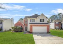 Charming two-story home featuring a brick facade, well-maintained lawn, and an attached two-car garage at 5300 Willow Park Blvd, Atlanta, GA 30349