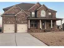 Charming two-story brick home with a covered front porch and a well-manicured lawn at 61 Denton Ct, Acworth, GA 30101