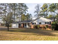 Charming single-story home with brick accents and a well-maintained front lawn in a wooded setting at 4149 Indian Lake Cir, Stone Mountain, GA 30083