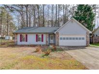 Charming single-story home featuring stone accents, red shutters, and a two-car garage at 629 Granite Ln, Loganville, GA 30052