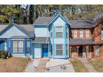 Charming blue two-story townhome featuring a bay window and manicured landscaping at 836 Heritage Oaks Dr, Stone Mountain, GA 30088