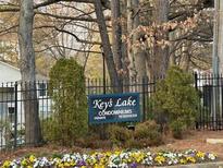 A welcoming sign to the Key's Lake Condominium residences with garden and trees at 1376 Keys Lake Ne Dr, Brookhaven, GA 30319
