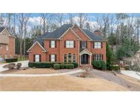 Charming two-story brick home with a manicured front yard and mature landscaping, showcasing classic architectural details at 5170 Deerlake Dr, Alpharetta, GA 30005