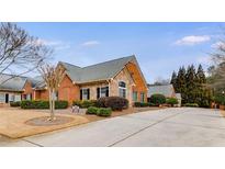 Charming brick home featuring a stone accent, mature landscaping, and a long driveway at 1404 Haven Cir, Douglasville, GA 30135