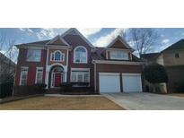 Elegant brick home featuring a two-car garage and well-manicured lawn and classic architectural design at 3302 Fieldwood Se Dr, Smyrna, GA 30080