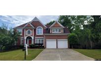 Traditional brick home featuring a two-car garage and manicured lawn, perfect for suburban living at 3302 Fieldwood Se Dr, Smyrna, GA 30080