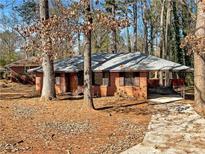 Charming brick home featuring mature trees, a covered porch, and inviting curb appeal at 4227 Pine Cir, Forest Park, GA 30297