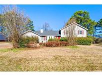 Charming single-Gathering home featuring a well-maintained lawn and traditional architecture with red shutters and front door at 1717 Ramblewood Way, Snellville, GA 30078