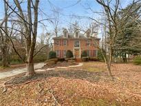 Charming two-story brick home featuring a manicured front lawn with mature trees at 1302 Milstead Ne Trce, Marietta, GA 30066